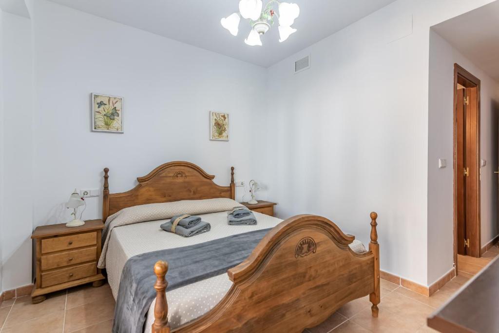 Un dormitorio con una cama de madera en una habitación. en Marina Esuri by Ĥ - Costa Esuri EEHM123P169, en Ayamonte