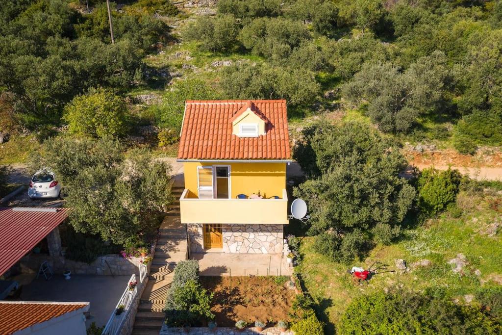Babino Polje的住宿－Dora&Paulo sweet countryside cottage，享有黄色房屋的顶部景色,设有红色屋顶
