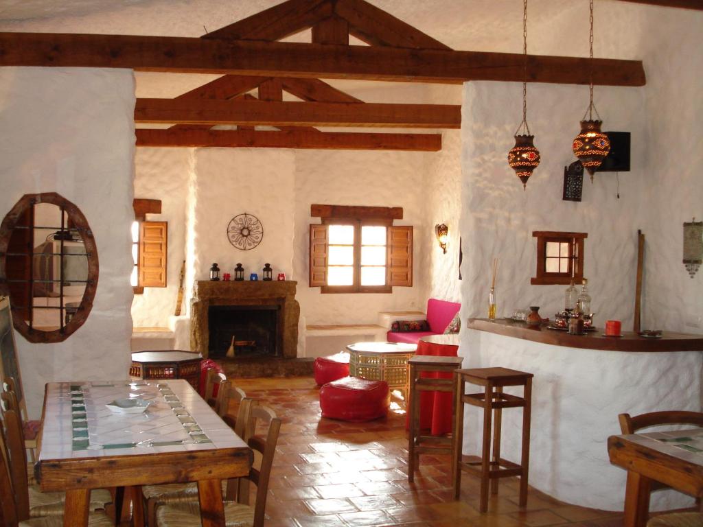 sala de estar con mesa y chimenea en Cueva de La Alegría, en Huéscar