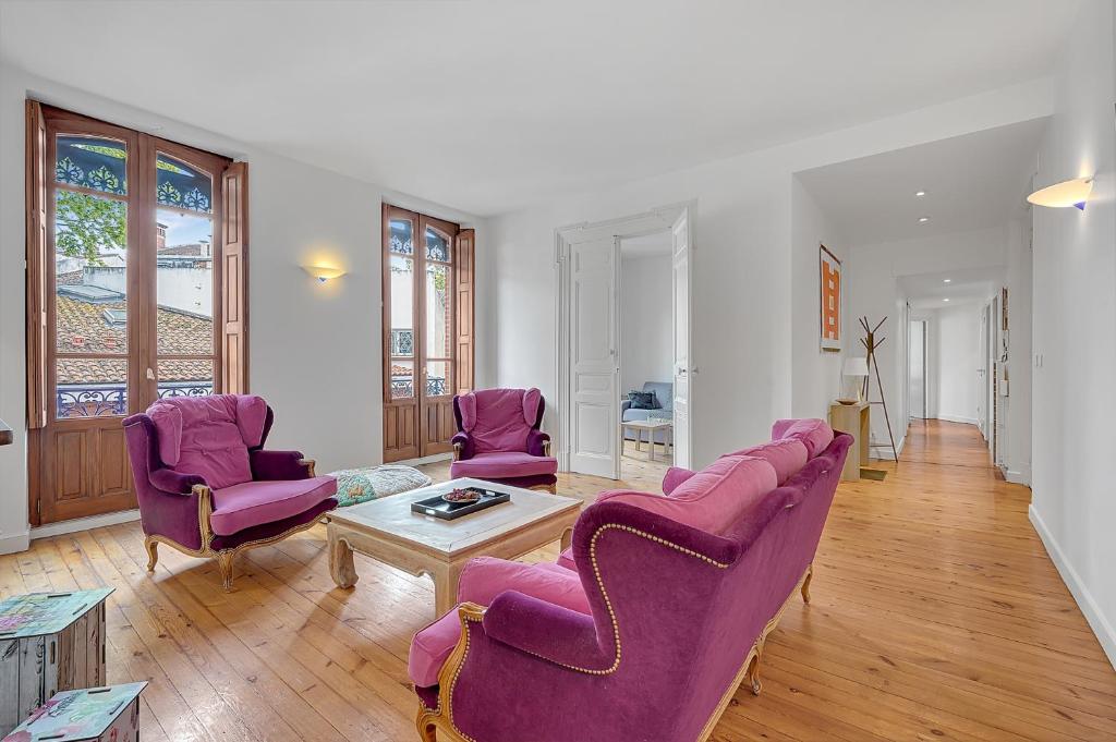 - un salon avec des chaises violettes et une table dans l'établissement LE MERCIER - Grand T4 de 100m2 en plein coeur de Toulouse, à Toulouse