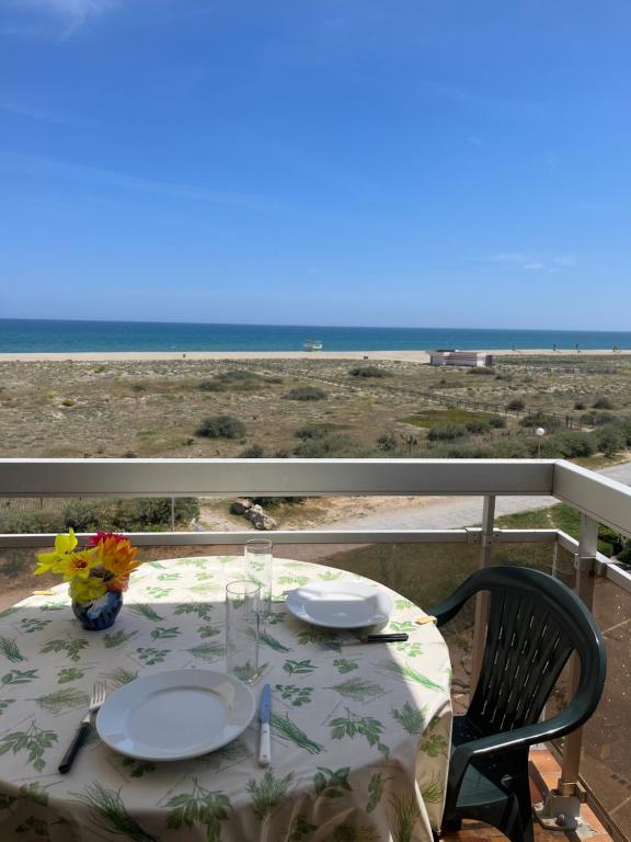 a table on a balcony with a view of the beach at Studio face à la mer - 2BALM38 in Le Barcarès