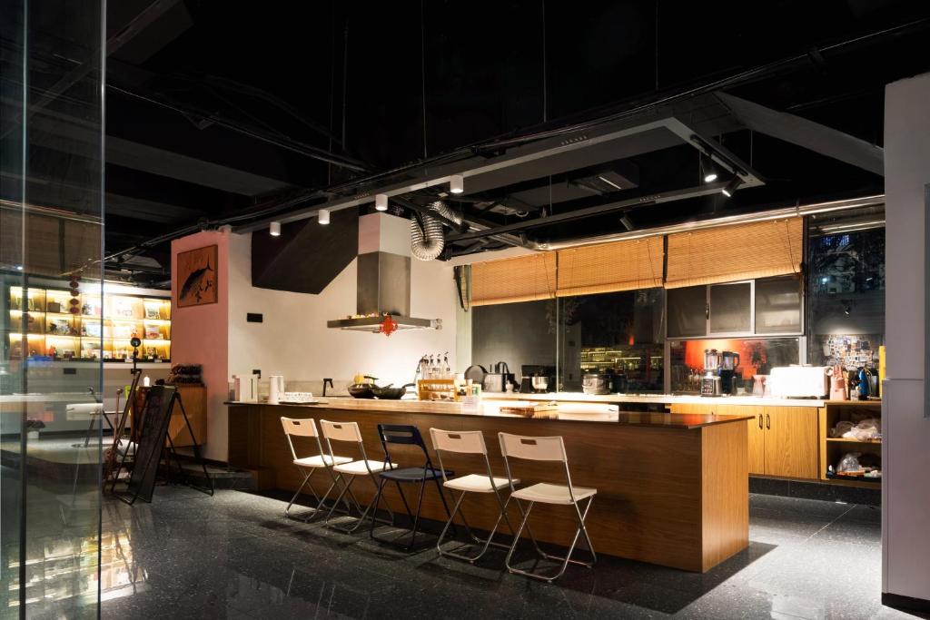 a kitchen with a counter with stools in it at 吃山文化青年旅店 in Chongqing