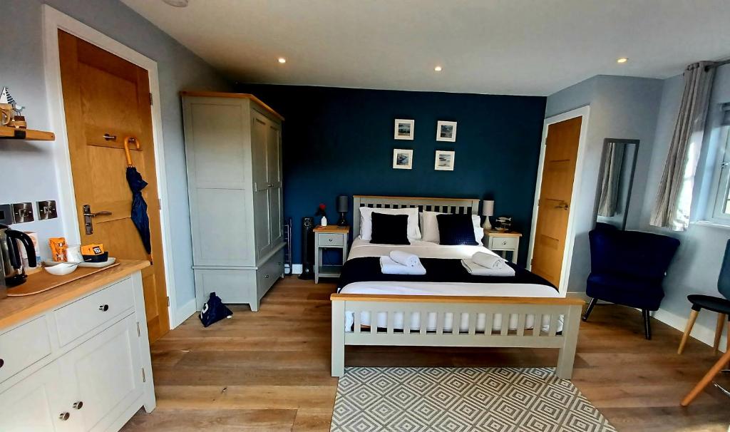 1 dormitorio con cama y pared azul en Stylish coastal retreat in St Ives en Carbis Bay