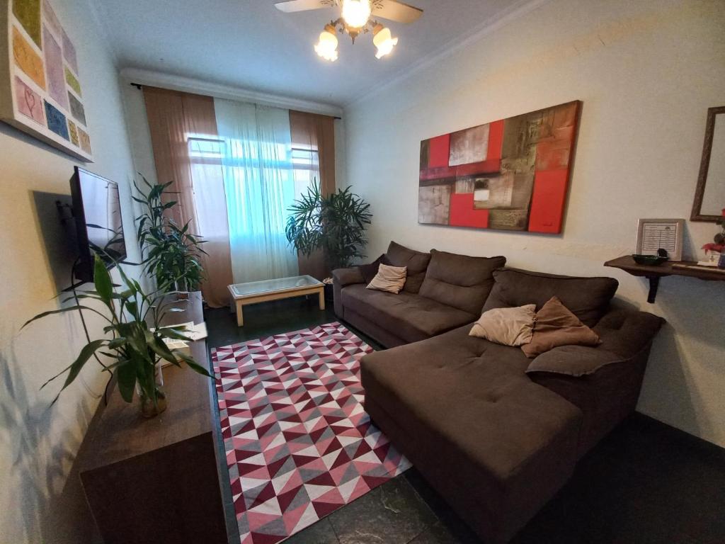 Apto 2 dormitórios no Boqueirão - Santos في سانتوس: غرفة معيشة مع أريكة وسجادة