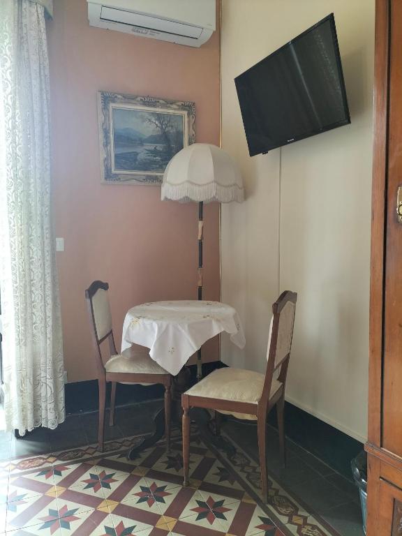 a table and two chairs and a television in a room at B&B Chapo in Catania