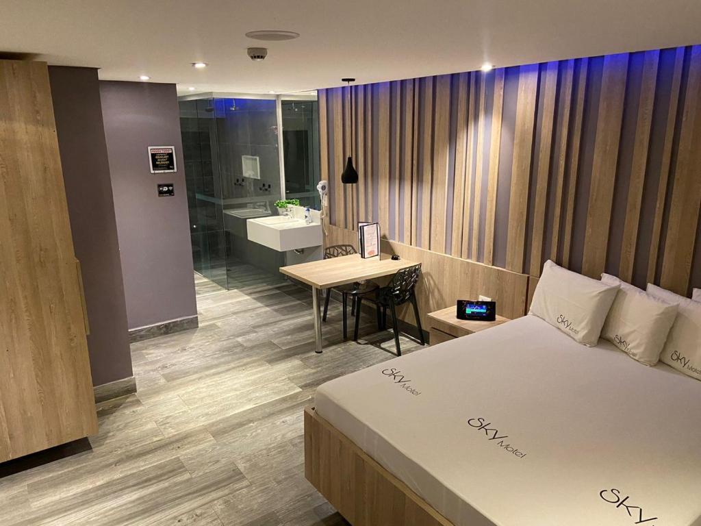 een hotelkamer met een bed en een badkamer bij Sky Motel Itaqua in Itaquaquecetuba