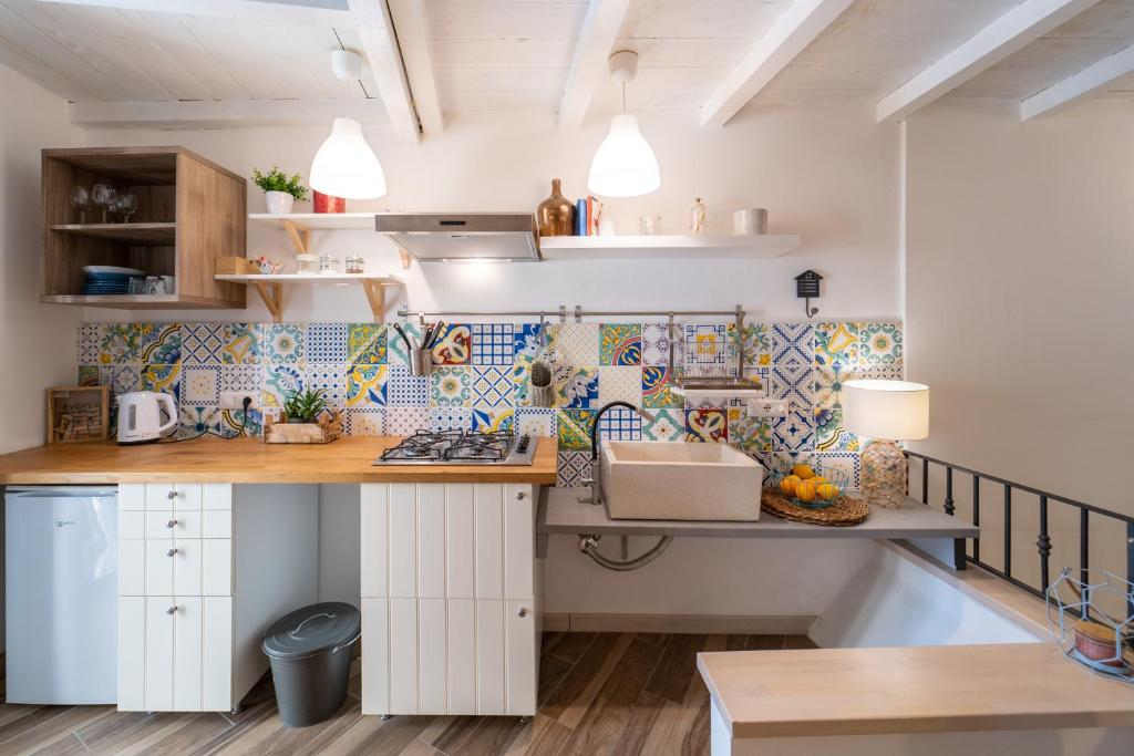 una cucina con armadietti bianchi e bancone di Casa Talete Cozy Apartment in Ortigia - FIRST FLOOR a Siracusa