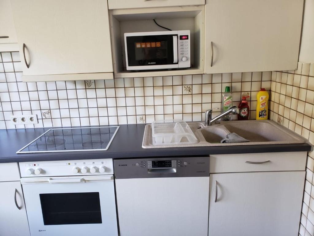 cocina con fregadero y microondas en Ferienwohnung - a68322 en Heidenheim an der Brenz