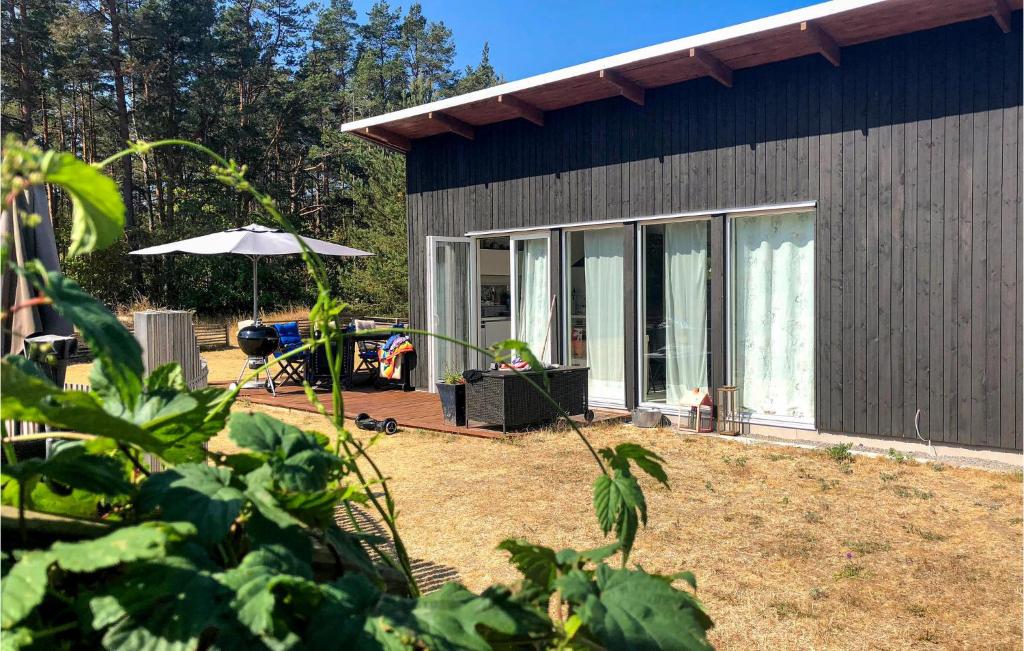 Casa pequeña con patio y sombrilla en Amazing Home In Kpingsvik With Wifi, en Köpingsvik