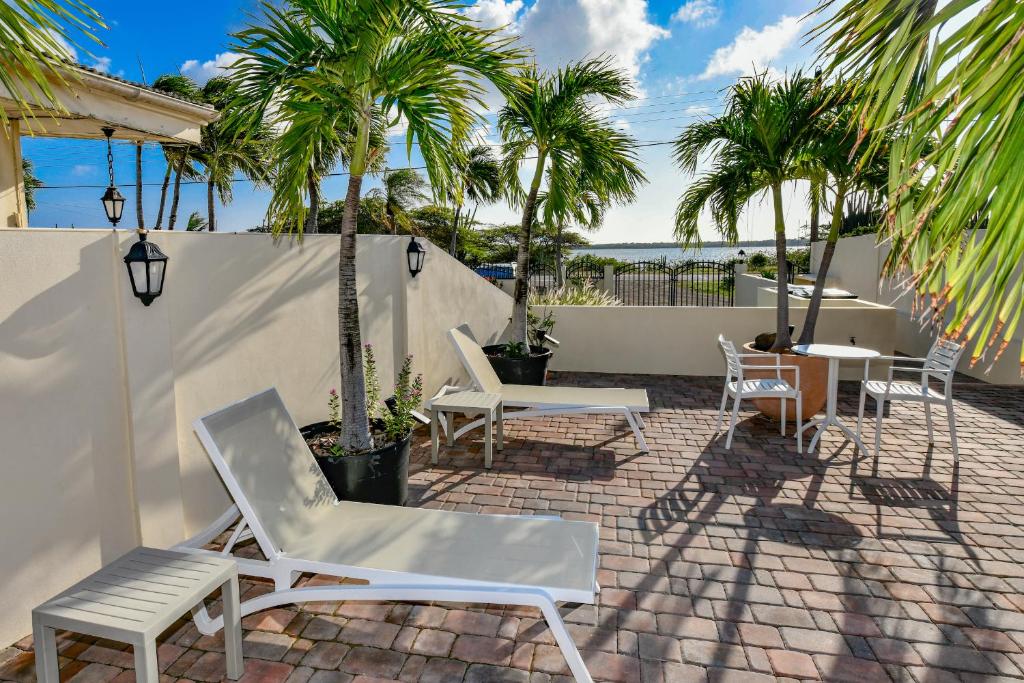 a patio with chairs and a table and palm trees at NEW Apartment Ocean View Amazing Sunsets in Sabana Berde