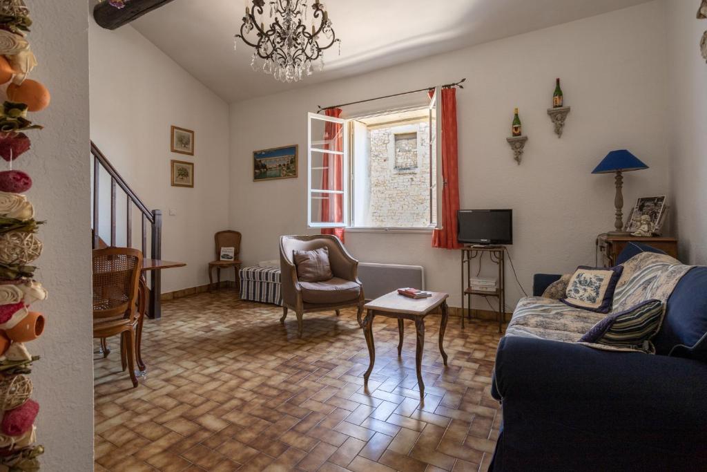 een woonkamer met een bank en een stoel bij Petit Paradis Nemausus in Nîmes