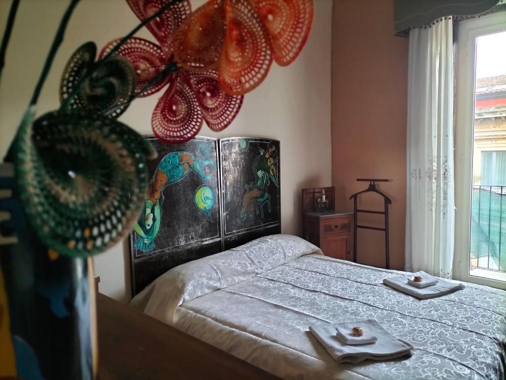 a bedroom with a bed with two plates on it at B&B Chapo in Catania