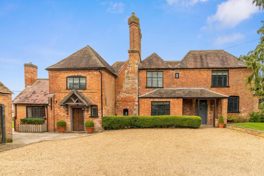 a large brick house with two chimneys at The Hunting Lodge at Ragley Estate in Alcester