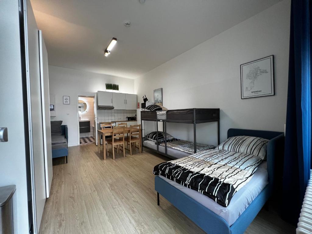 fairAPART Studio-Apartment nähe klein Venedig في برلين: غرفة نوم بسرير ومطبخ مع طاولة