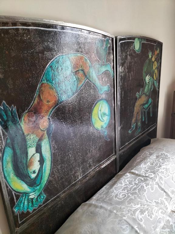 a book with a painting on the back of a bed at B&B Chapo in Catania