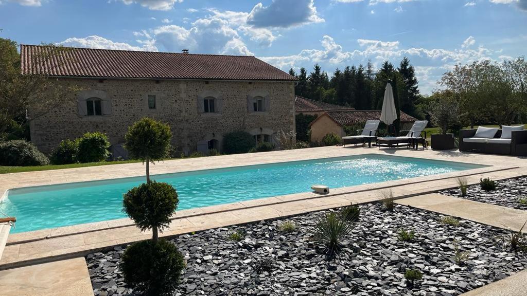 a swimming pool in front of a house at TENDANCE CAMPAGNE Chambre d'hôtes in Marillac