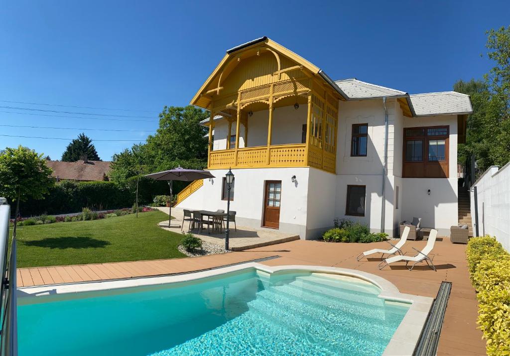 a house with a swimming pool in front of it at Segesdy Villa in Balatonalmádi