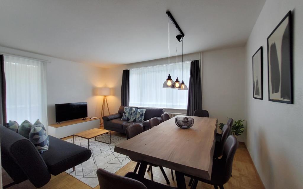 uma sala de estar com uma mesa e uma sala de estar com um sofá em Apartment Via Surpunt - Casa - 5 Rooms em St. Moritz