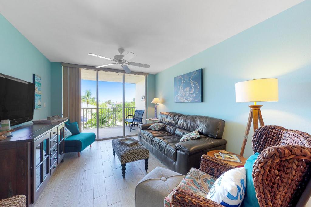 a living room with a couch and a tv at Hamilton House 206 in Clearwater Beach