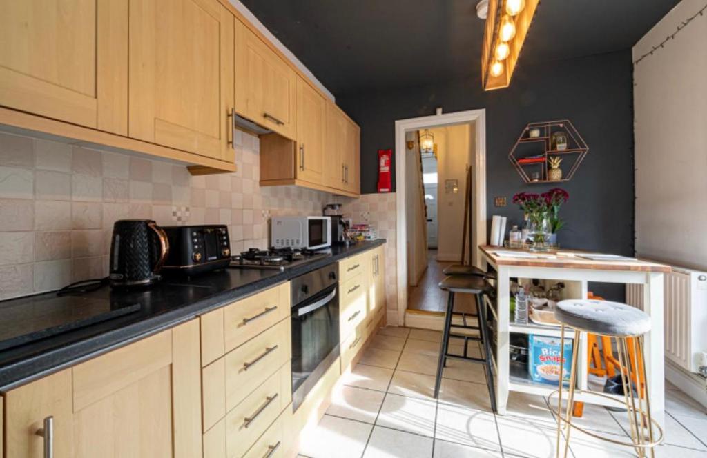 a kitchen with wooden cabinets and a counter top at Stunning Victorian House in Hull