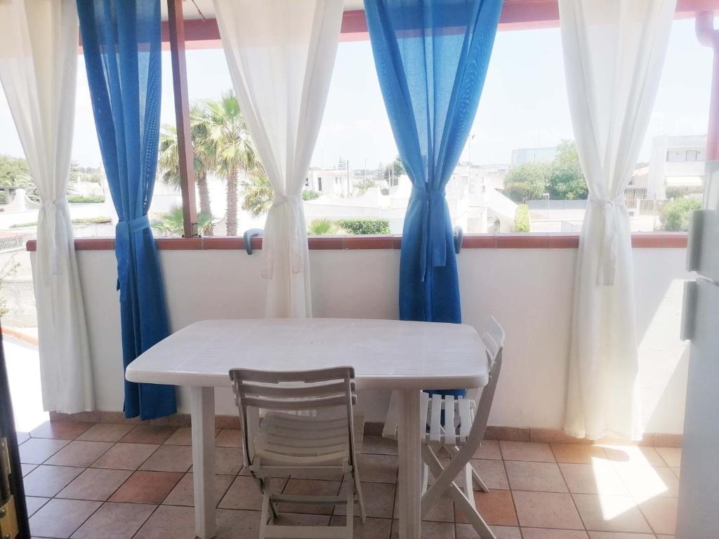 1 mesa y 2 sillas en una habitación con ventana en Casa Sonica, en Maruggio