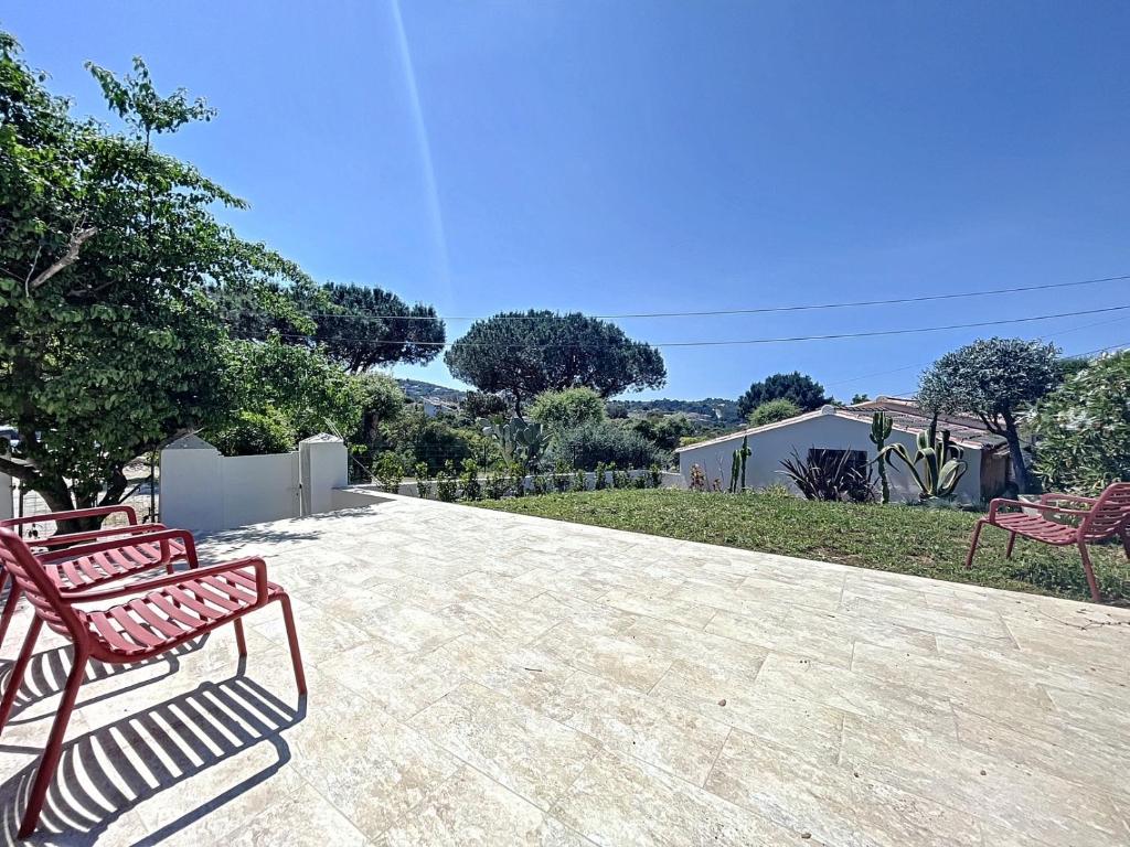 Due panche rosse sono sedute su un patio di Villa du golf- Porticcio a Porticcio