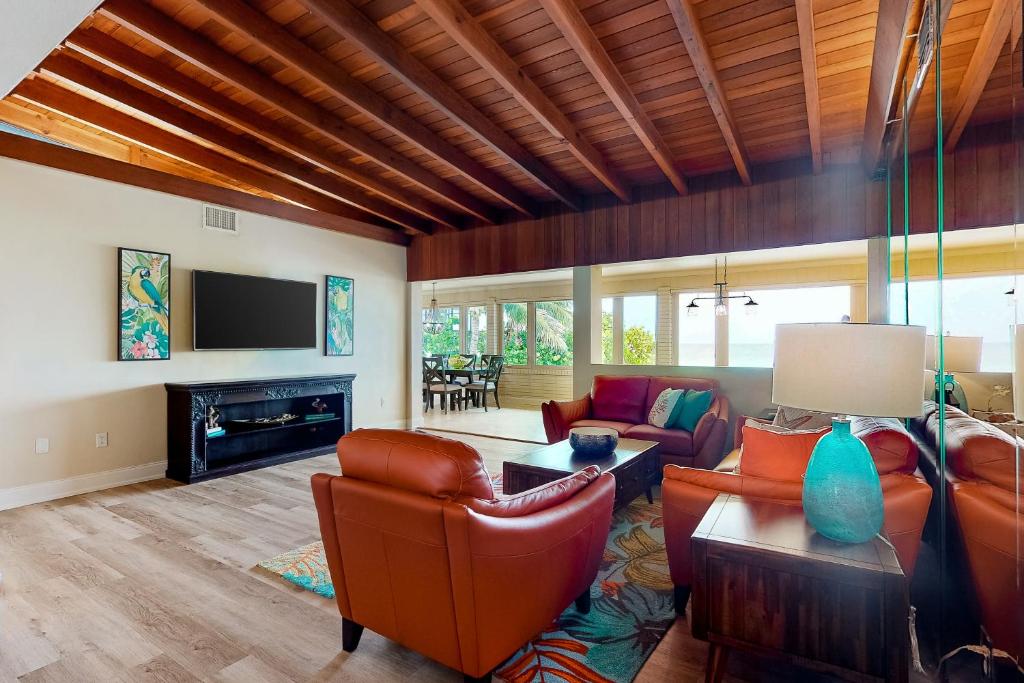 a living room with leather furniture and a tv at Sugar Sands C in St. Pete Beach