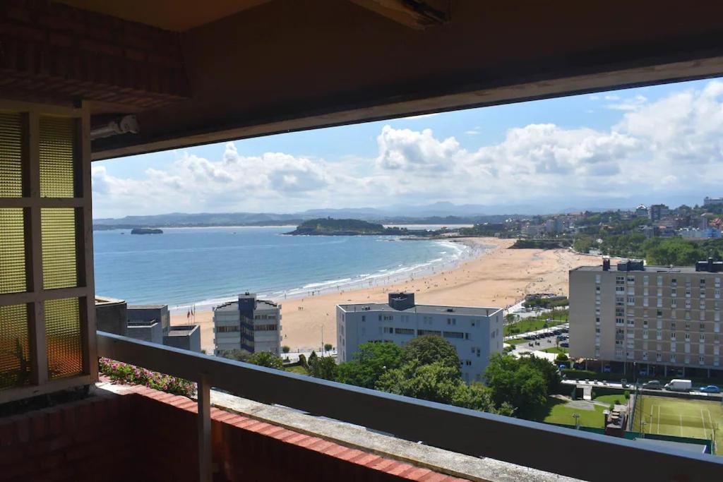 a view of a beach and the ocean from a balcony at Vistas increíbles! a 3 minutos de la playa con Wifi in Santander
