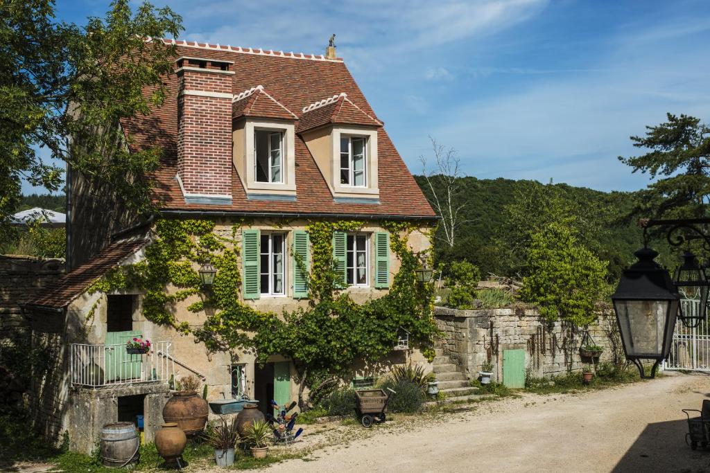 an old house with green shutters on a street at Le Domaine des Carriers - Gites in Chevroches