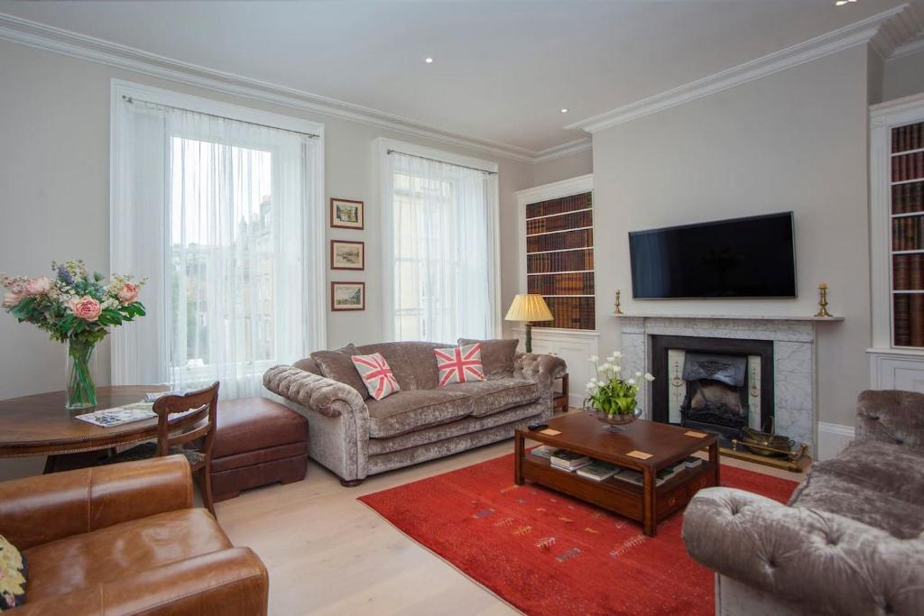a living room with a couch and a fireplace at Blenheim House - Luxury City Centre Georgian Townhouse for 8 in Bath