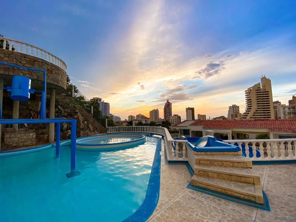 ein großer Pool mit einer Skyline der Stadt im Hintergrund in der Unterkunft Villa Roca, Rodadero in Santa Marta