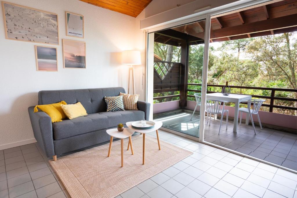 a living room with a couch and a table at Chaleureux appartement à 500m de l’océan et 150m du Golf Moliets-Plage in Moliets-et-Maa