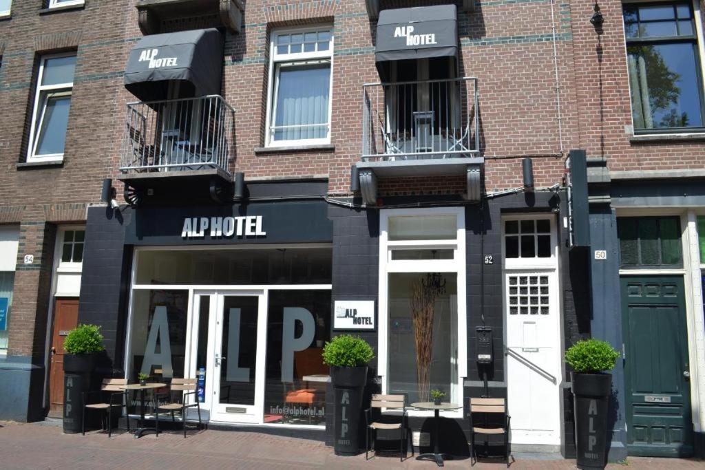 ein Geschäft vor einem Backsteingebäude in der Unterkunft Alp Hotel in Amsterdam