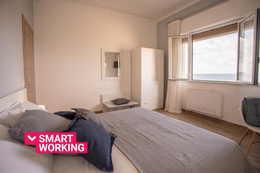 Un dormitorio con una cama grande y una ventana en Seaview Rooms in the center by Wonderful Italy, en Cefalú