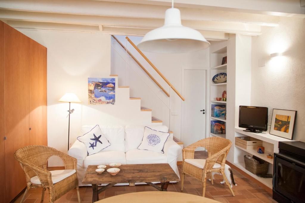 een woonkamer met een witte bank en stoelen bij Let's Holidays NICE HOUSE CLOSE TO THE CASTLE in Tossa de Mar