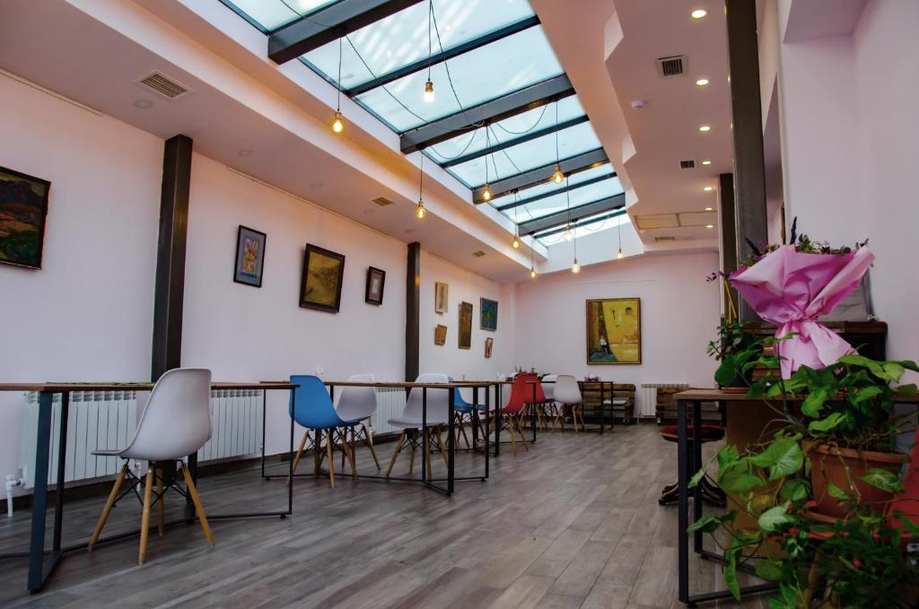 um quarto com mesas e cadeiras e uma clarabóia em Blur Inn Gallery em Yerevan