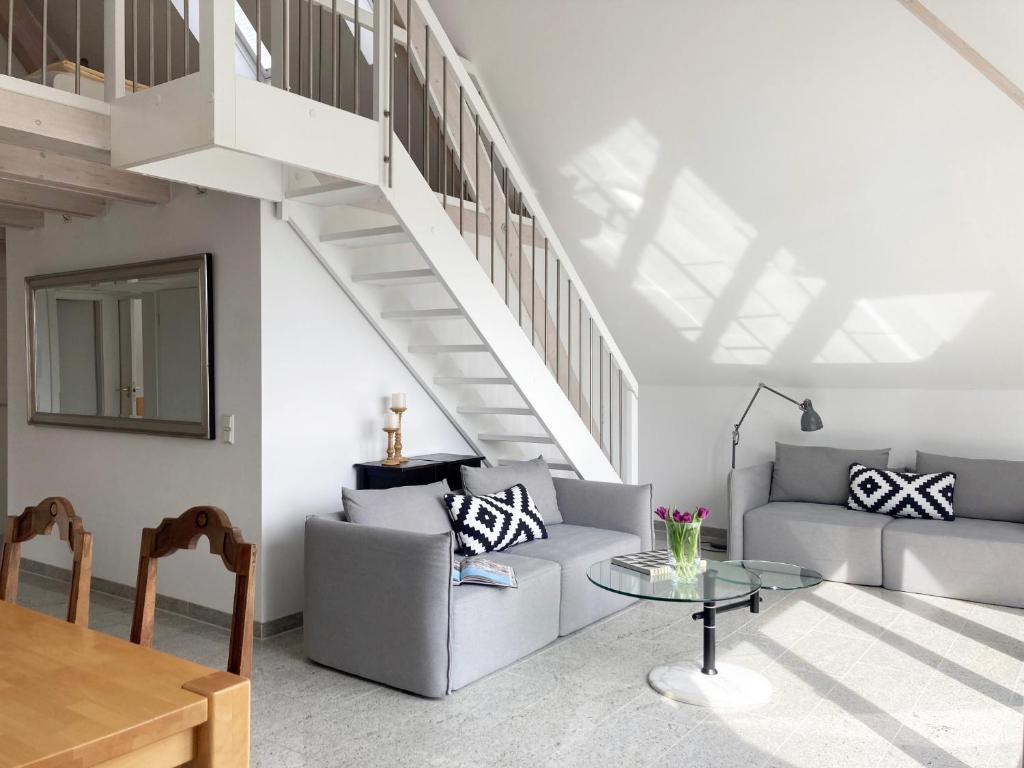 ein Wohnzimmer mit einer Treppe und einem Tisch in der Unterkunft Villa Grünewald in Überlingen