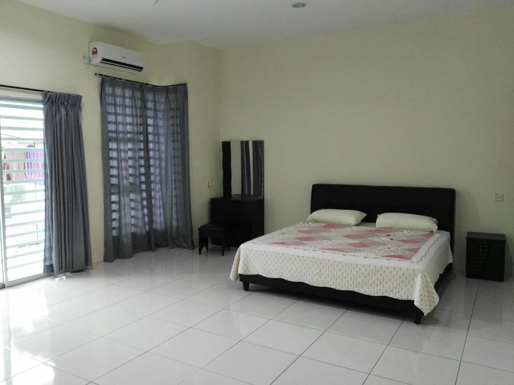 a bedroom with a bed and a large window at Fong's Ipoh SImpang Pulai Homestay in Ipoh