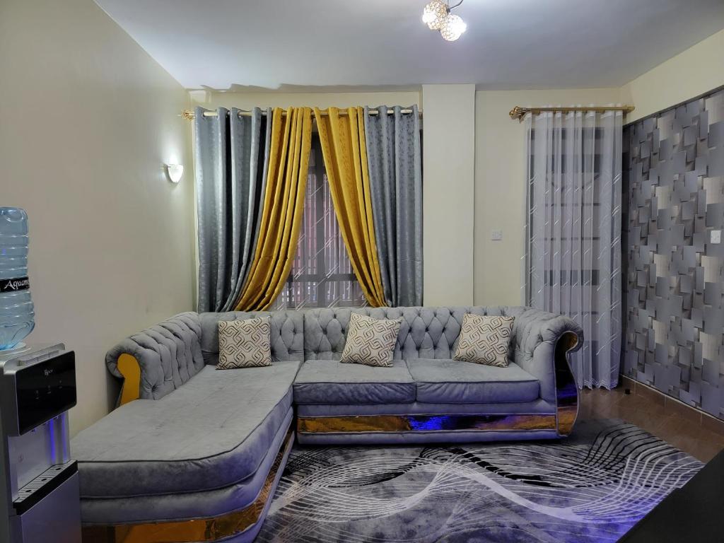 a living room with a couch in front of a window at Classy Apartment Near all Embassies in Ruaka