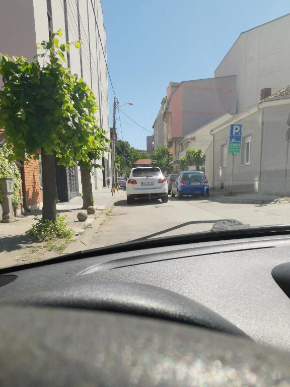 ニシュにあるNavissos Heaven Luxury Apartmentの道路に駐車している車がある通りを走る車