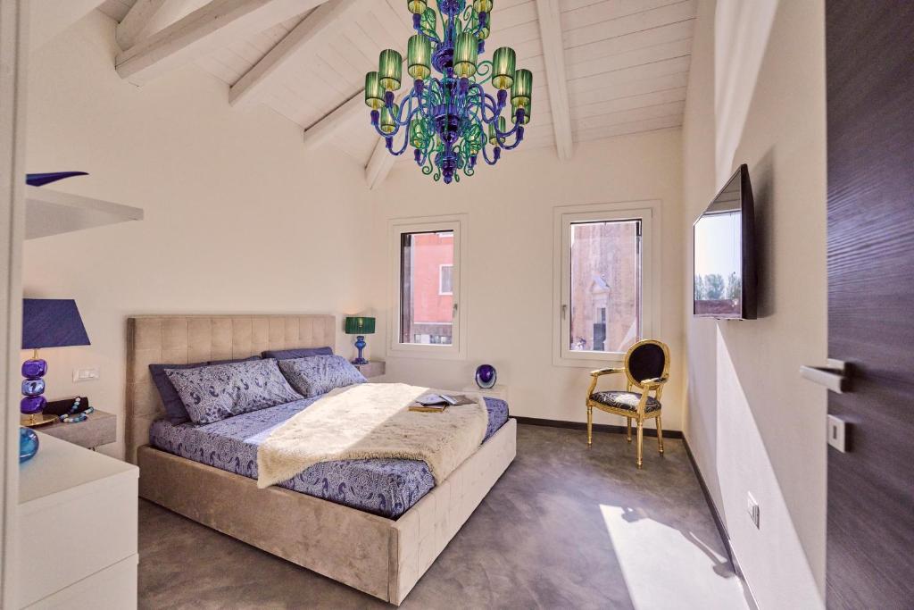 sypialnia z dużym łóżkiem i żyrandolem w obiekcie Simone Cenedese Murano Apartments - Cristallo w mieście Murano