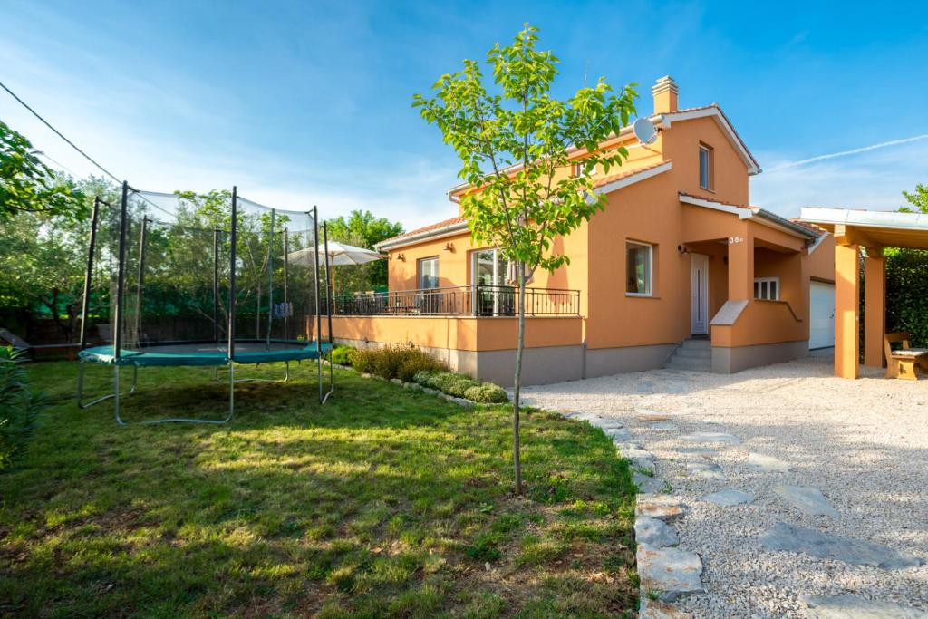 podwórko z huśtawką przed domem w obiekcie Holiday house TOIĆI w Krku