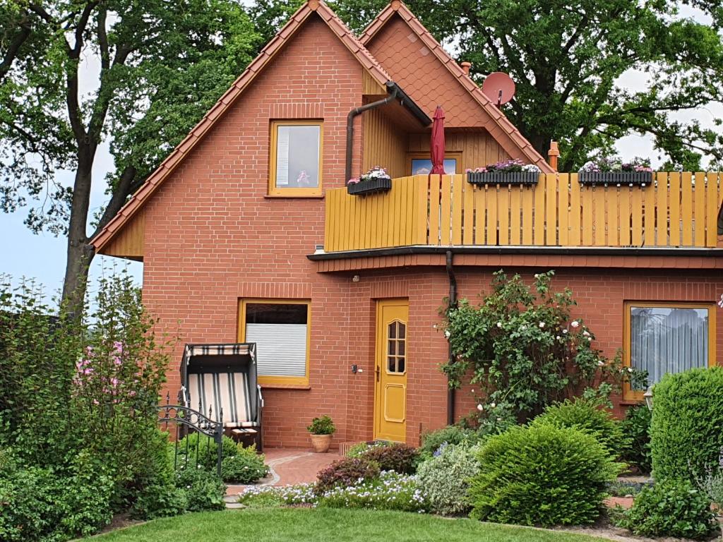 una casa de ladrillo rojo con puerta amarilla en Ferienwohnung Heike Heitmann, en Eystrup