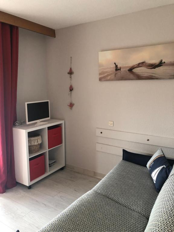 une chambre avec un lit et une télévision sur un mur dans l'établissement studio avec climatisation WIFI parking piscine, au Cap d'Agde