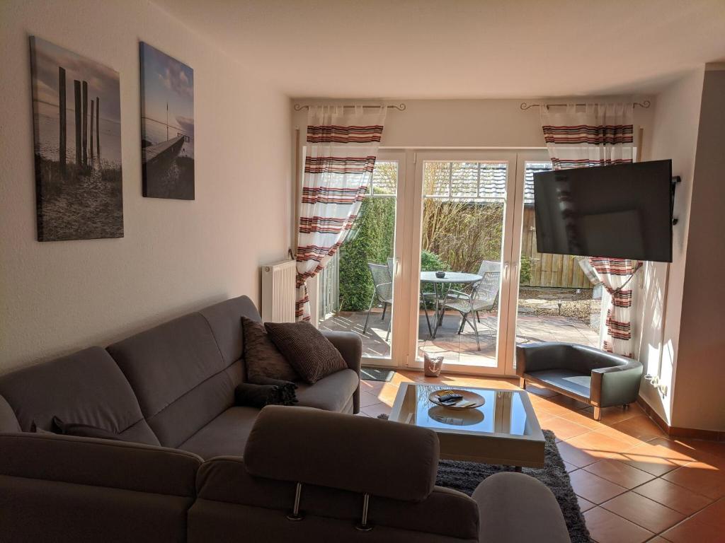 a living room with a couch and a tv at Austernfischer Ferienwohnung in Dangast