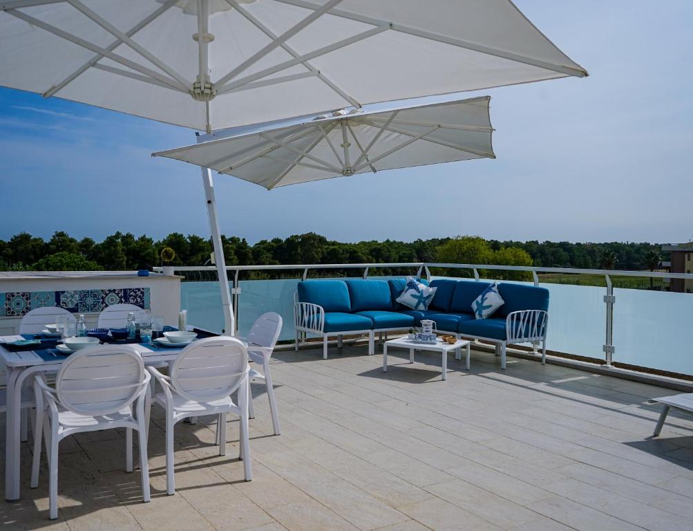 a patio with a table and chairs and an umbrella at NSM Blumarine Luxury home in Campomarino