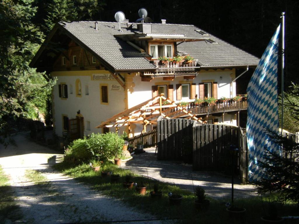 a house with a fence and a flag in front of it at Gassermühle-Zimmer für Selbstversorger in Eggen