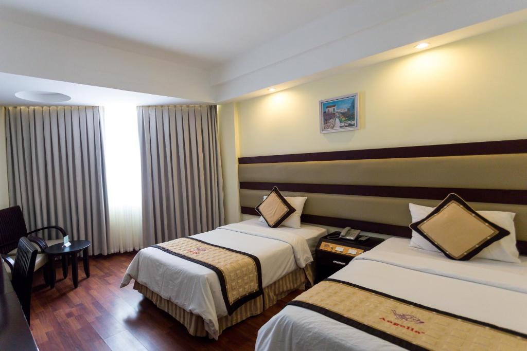Postel nebo postele na pokoji v ubytování Angella Hotel