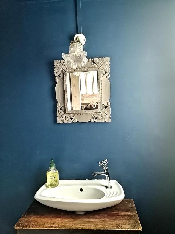 a bathroom with a sink and a mirror on a blue wall at La Bonne Etoile, près Giverny in Vernon
