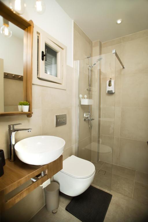 a bathroom with a toilet and a sink and a shower at Horizon Hotel Kalymnos in Myrties